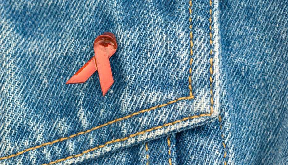 Denim jacket with AIDS awareness pin.