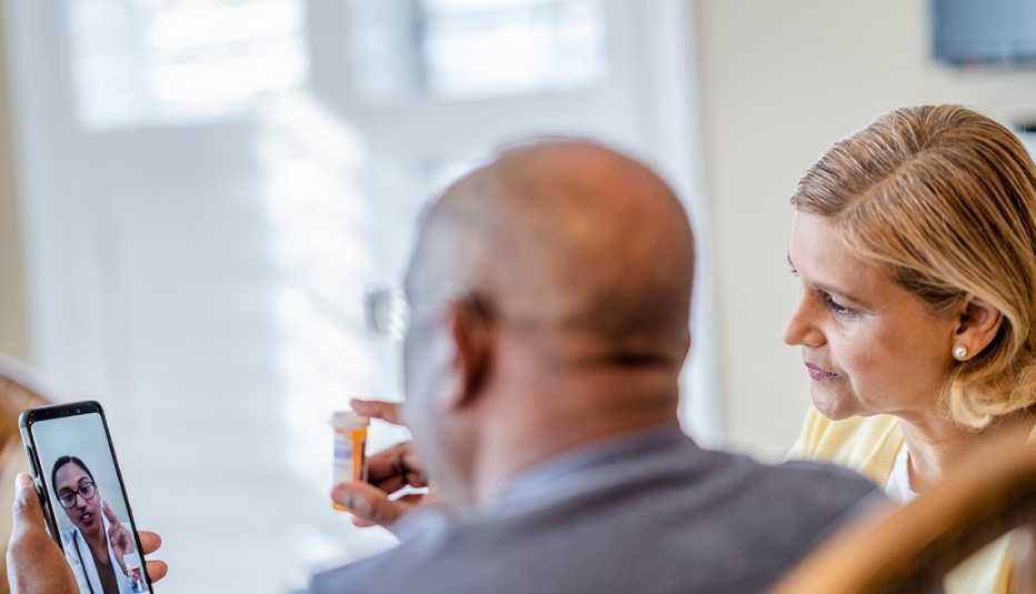 A man and woman talking to their doctor via telemedicine.
