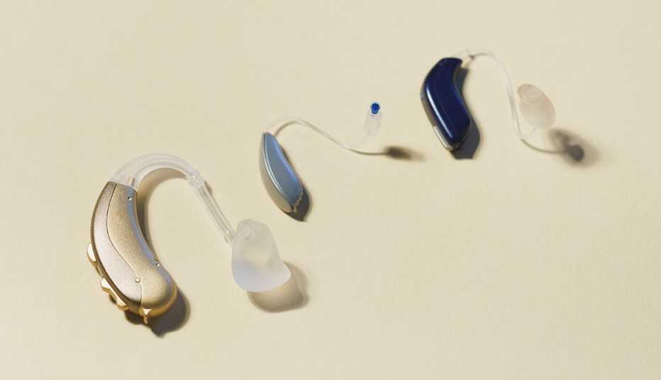various hearing aids on a beige background