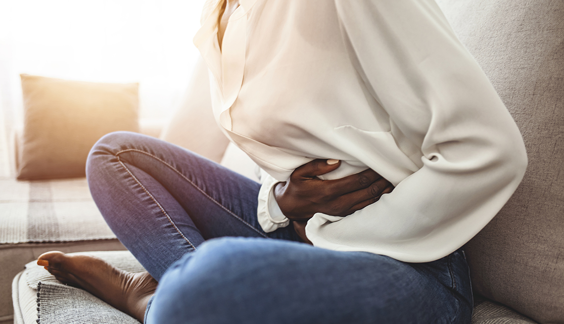 woman having stomach pains, holding her stomach