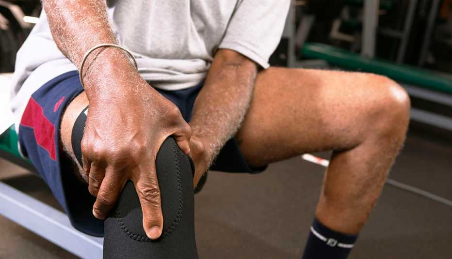 man working out holds his knee