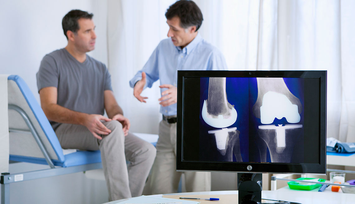 Doctor examining patient's kneww