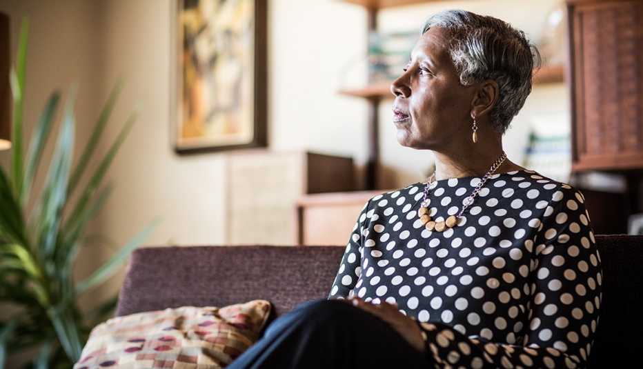 A woman sitting on couch at home.