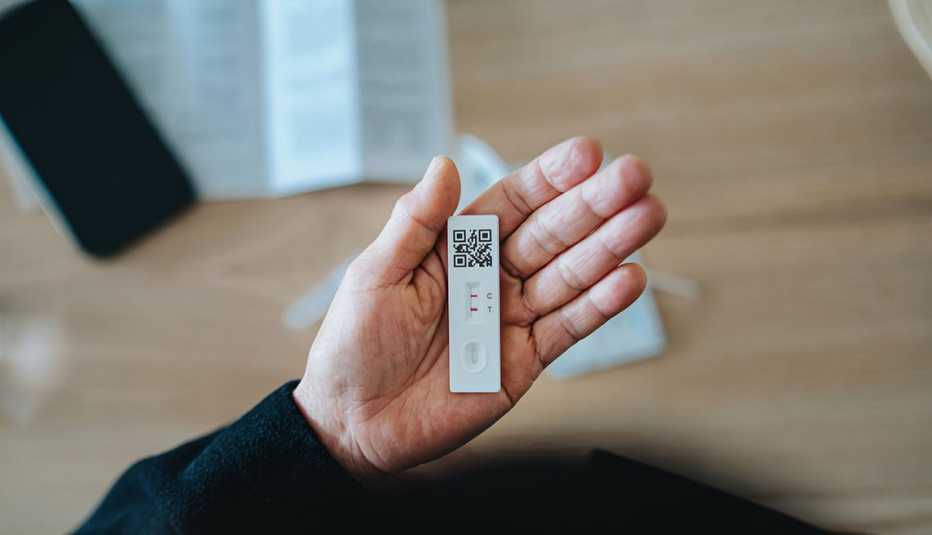 overhead view of someone holding a positive home covid test