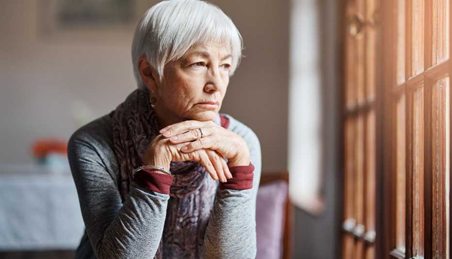 Woman looking sad, staring at a window