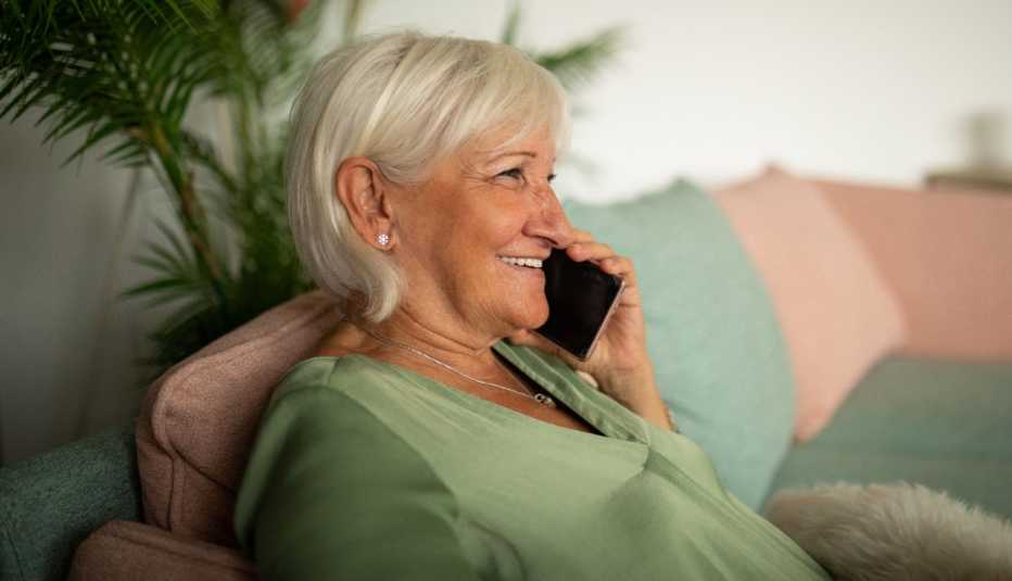woman sitting on the couch using her smart phone for a home hearing test