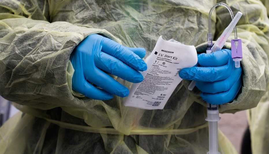 a healthcare worker prepares an infusion for a patient at a drive-thru monoclonal antibody treatment center