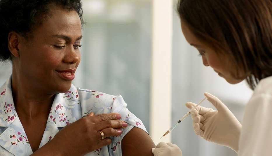 A doctor is giving a shot to a woman patient