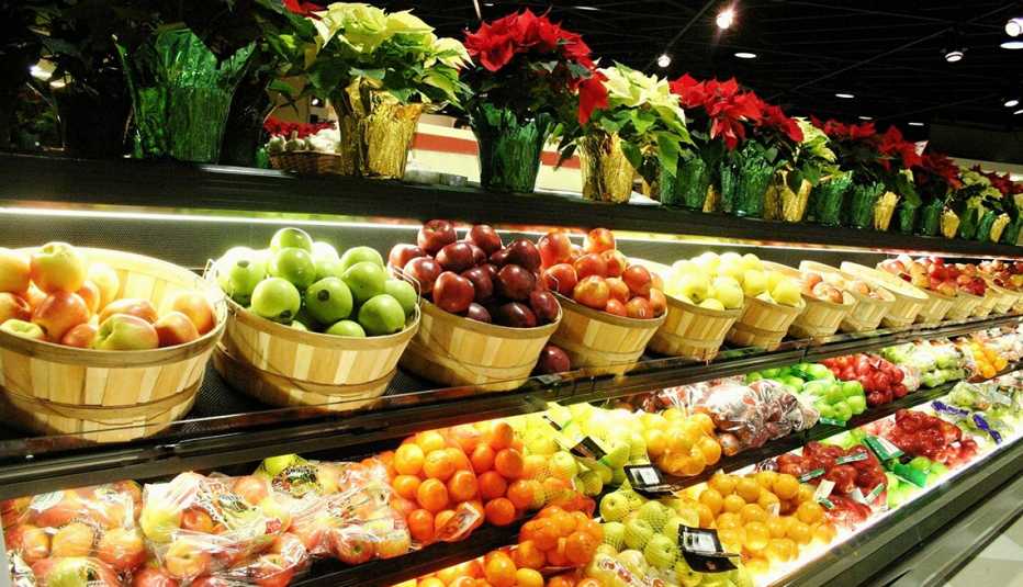 a shelf in the produce section of a supermarket filled with fruits that have been recalled and holiday poinsettia plants