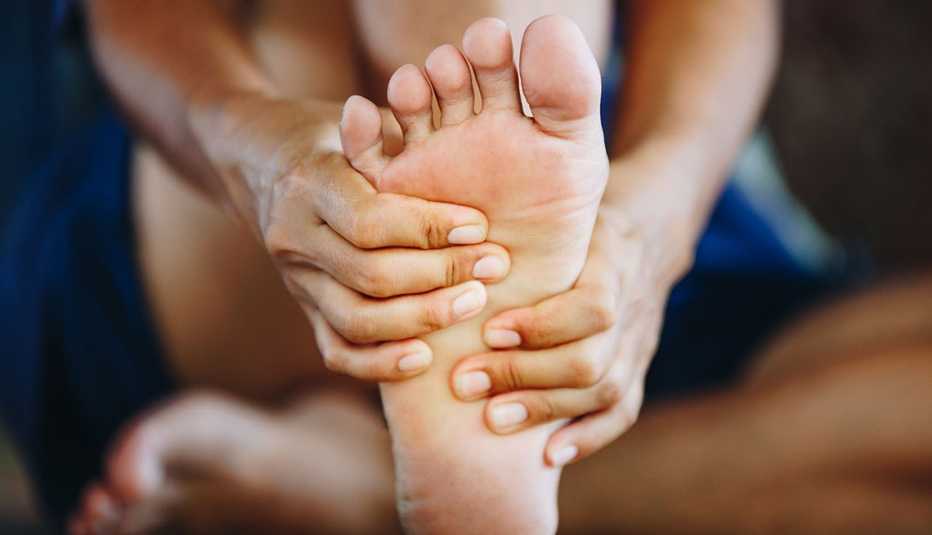 close up shot of a woman holding her foot in pain