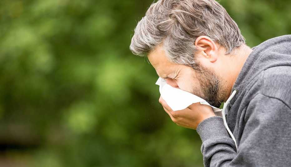 man sneezing outdoors