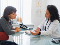 Doctor with female patient in office - Task Force Finds Ovarian Cancer Screening Not Always Effective Doctor with female patient in office - Task Force Finds Ovarian Cancer Screening Not Always Effective