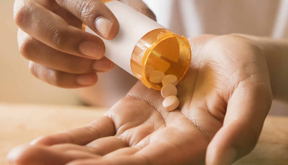 Hands of a woman holding prescription medicine.