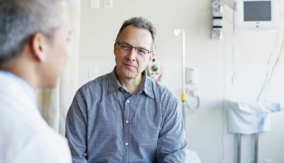 doctor talking to male patient in hospital room