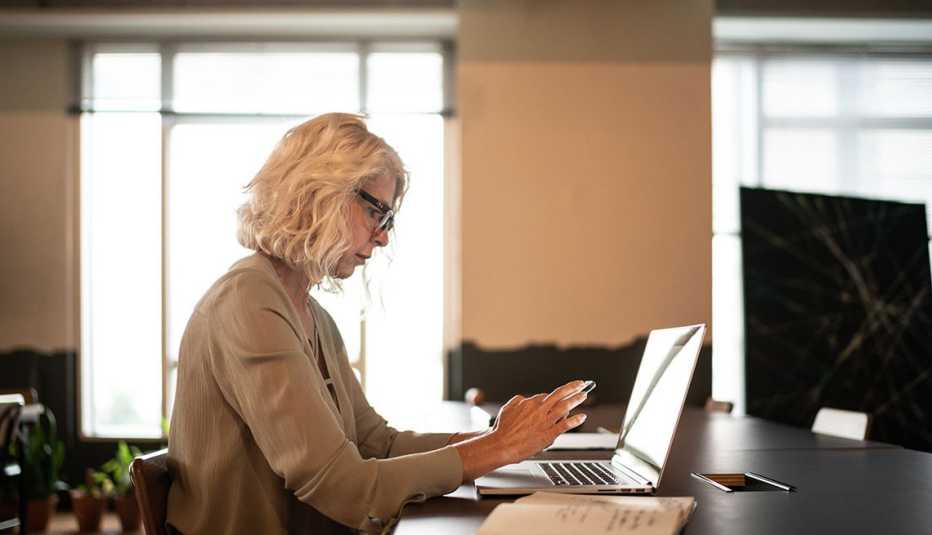 woman distracted by her phone while working
