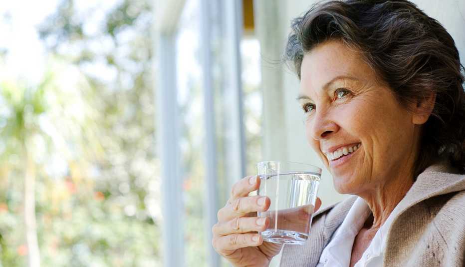 woman drinking a glass of water in the doorway