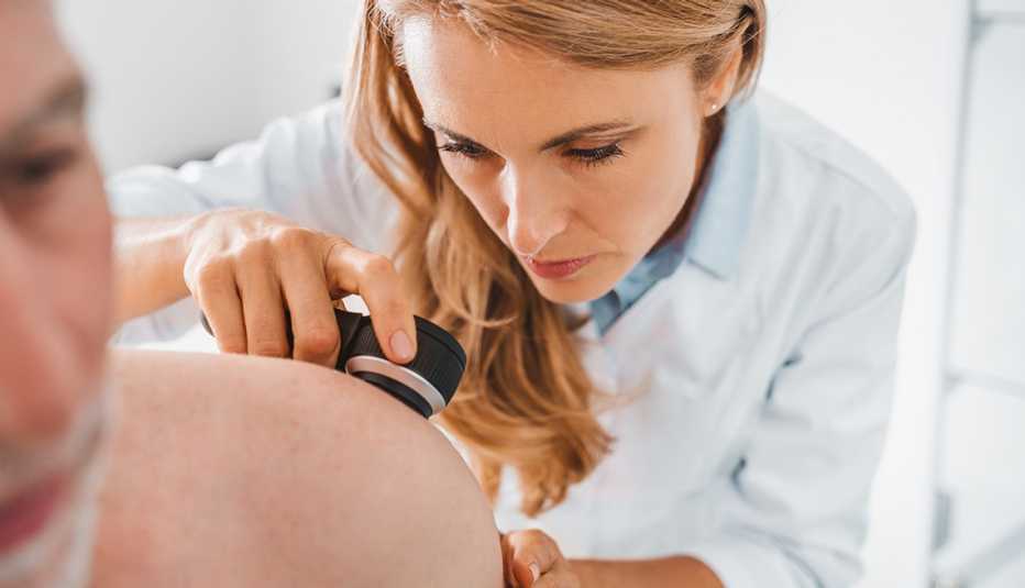 Doctor dermatologist examines skin of patient. 