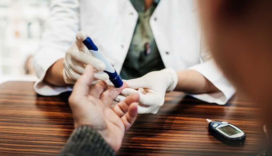 doctor checking a person's blood sugar with a finger stick