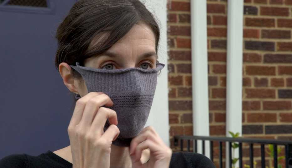 woman placing face mask made out of a sock