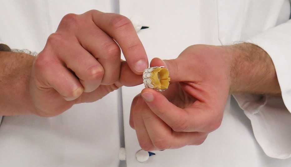 a cardiologist shows the valve that's used in a minimally invasive procedure called transcatheter aortic valve replacement, which is an alternative to open heart surgery for some patients