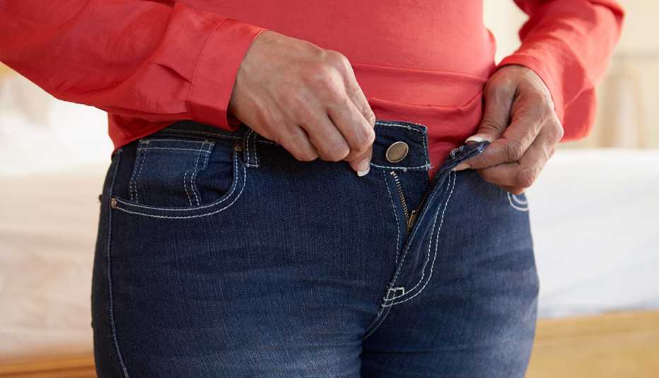 Woman buttoning her jeans.