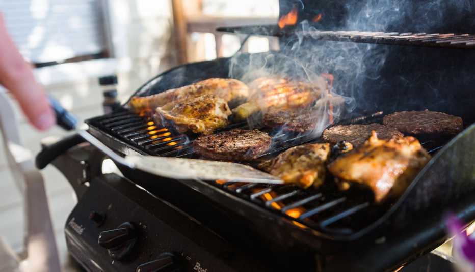 Chicken and hamburgers cooked on outdoor gas grill