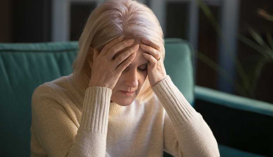 A woman places her hands on her forehead as she deals with a case of vertigo