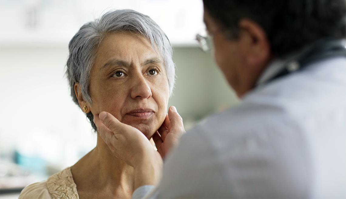 Hispanic doctor examining neck of patient