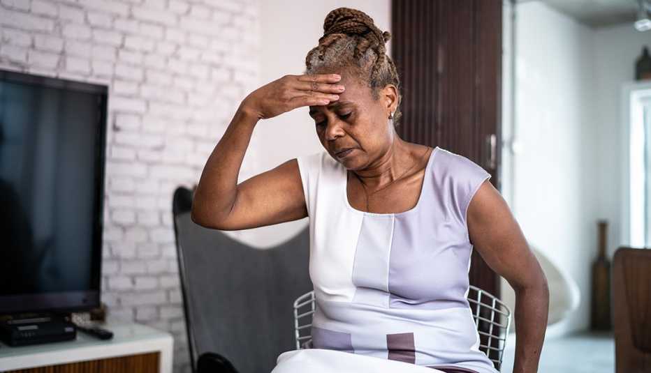 woman feeling poorly, she has her hand on her head