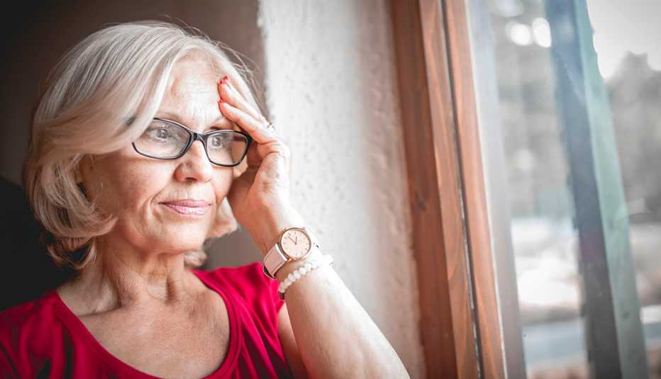 Mature woman looking sad near window