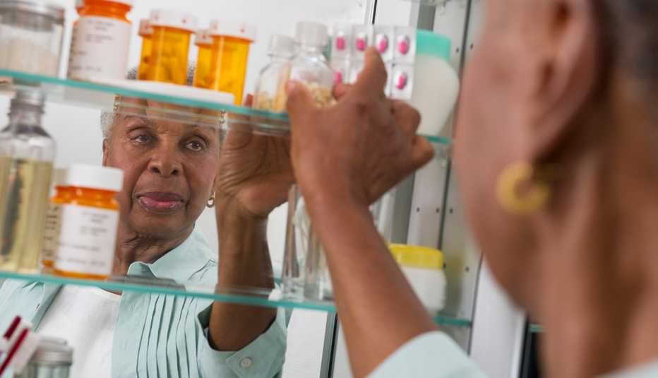 woman reaching into her medicine cabinet