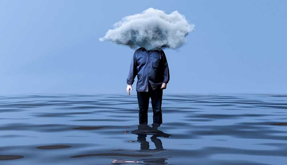 man standing in calf high rippling water with his head obscured by a gray stormy cloud