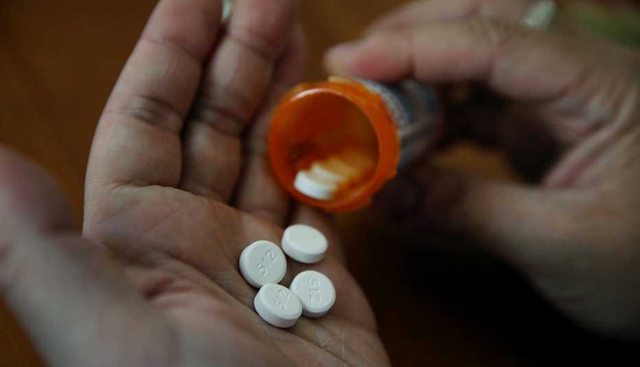 pills from a prescription bottle in a man's hand pills from a prescription bottle in a man's hand