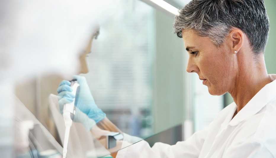 medical researcher uses a pipette while working on an experiment