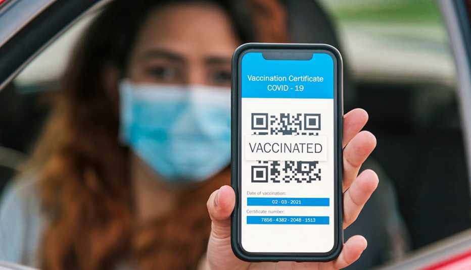 Woman showing her vaccine certificate on her smart phone. 