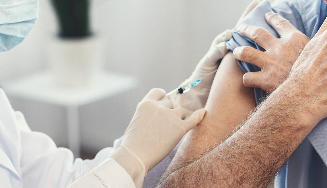 Doctor giving a flu shot to a man.
