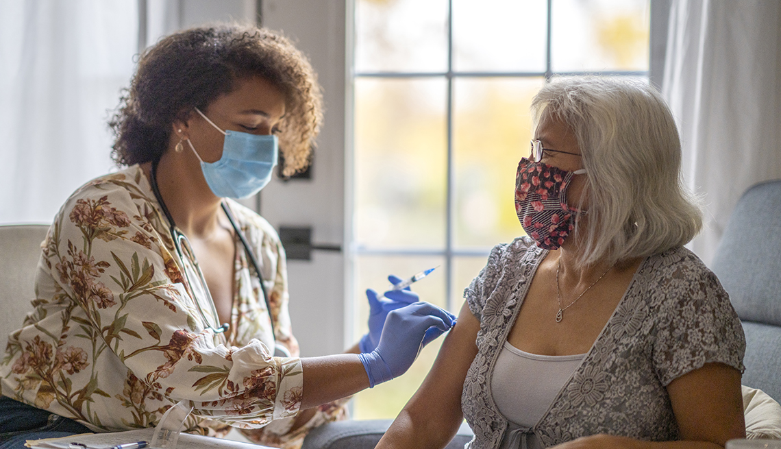 A woman is getting a vaccine at home