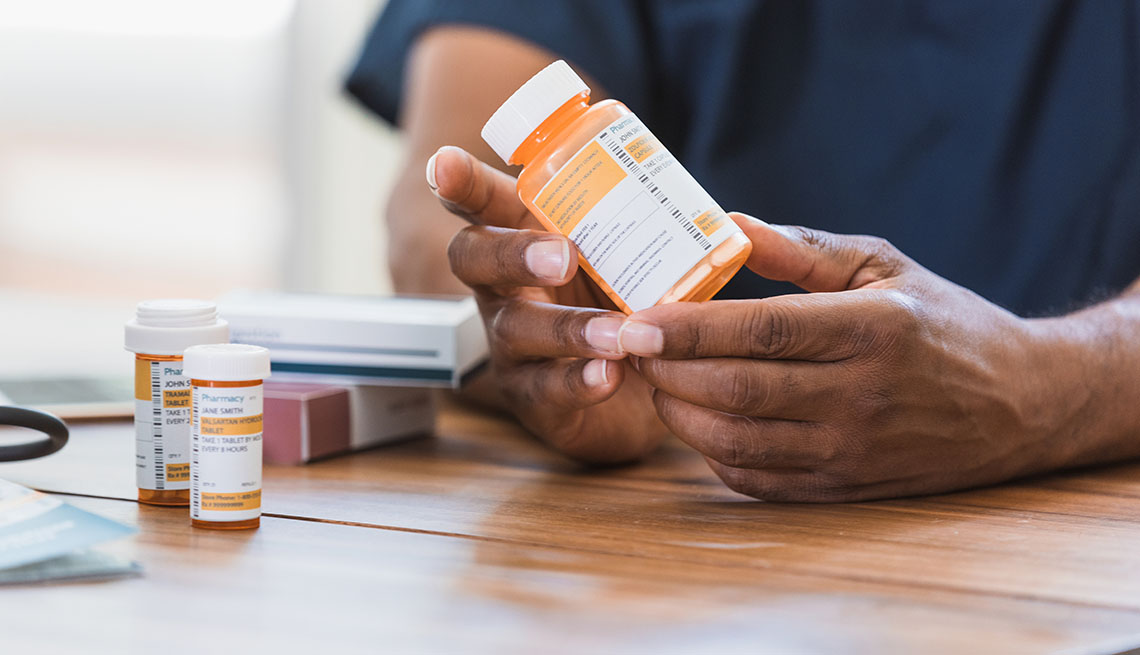 man examines prescription bottle