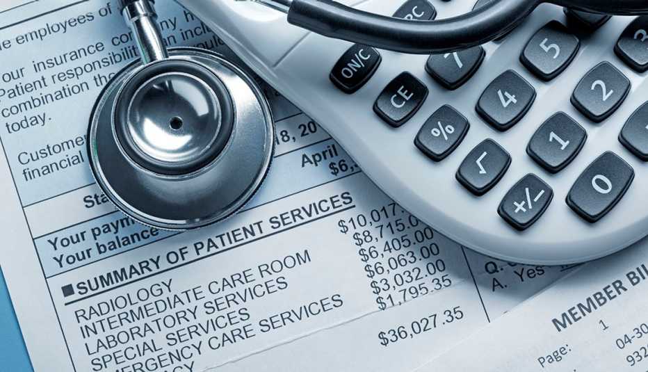 a stethoscope and a calculator rest on top of a medical bill.