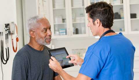 nurse talking to male patient in doctor's office
