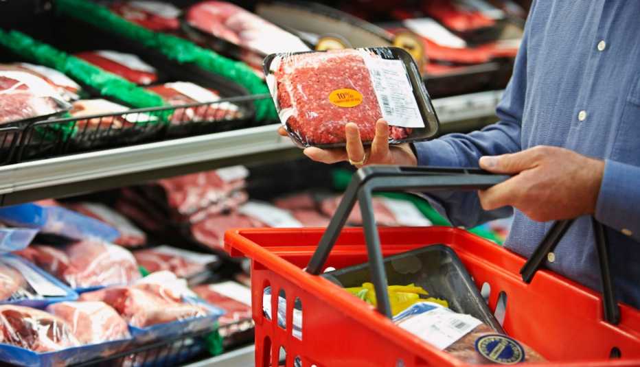 man shopping for ground beef in the grocery store
