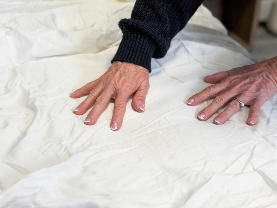 A woman placing her hands on the Cozy Earth Bamboo Sheets