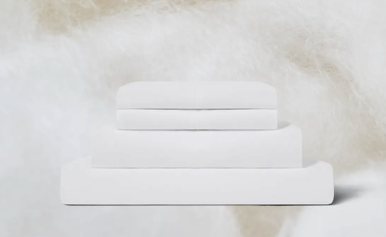 A stack of the Birch Organic Cotton Sheet Set on a textured background
