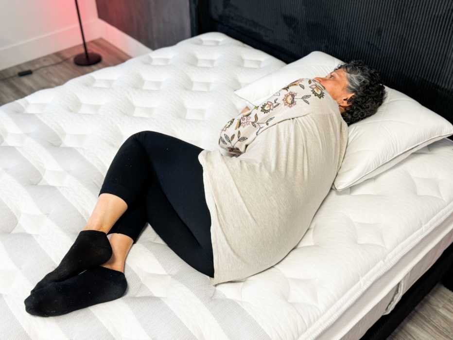 Woman laying on her side on a mattress