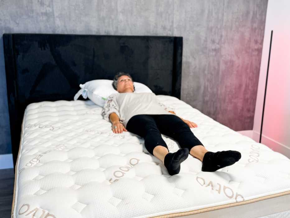 A woman lying on her back on a mattress