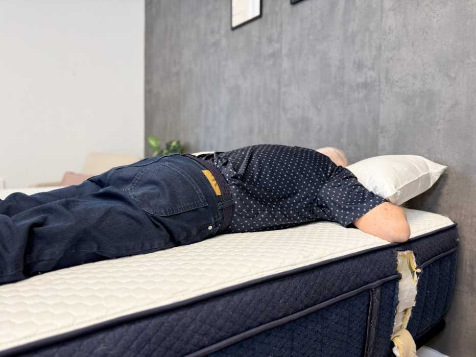 A man lying on his stomach on a mattress