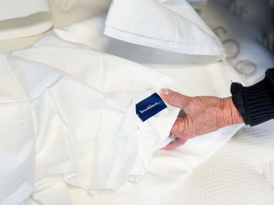 A close-up of the Brooklinen label on the flat sheet of the Brooklinen Luxe Sateen Core Sheet Set.