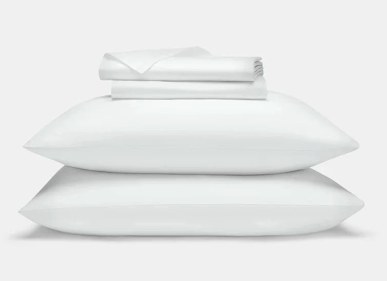 The Brooklinen Luxe Sateen Core Sheet Set stacked with pillows