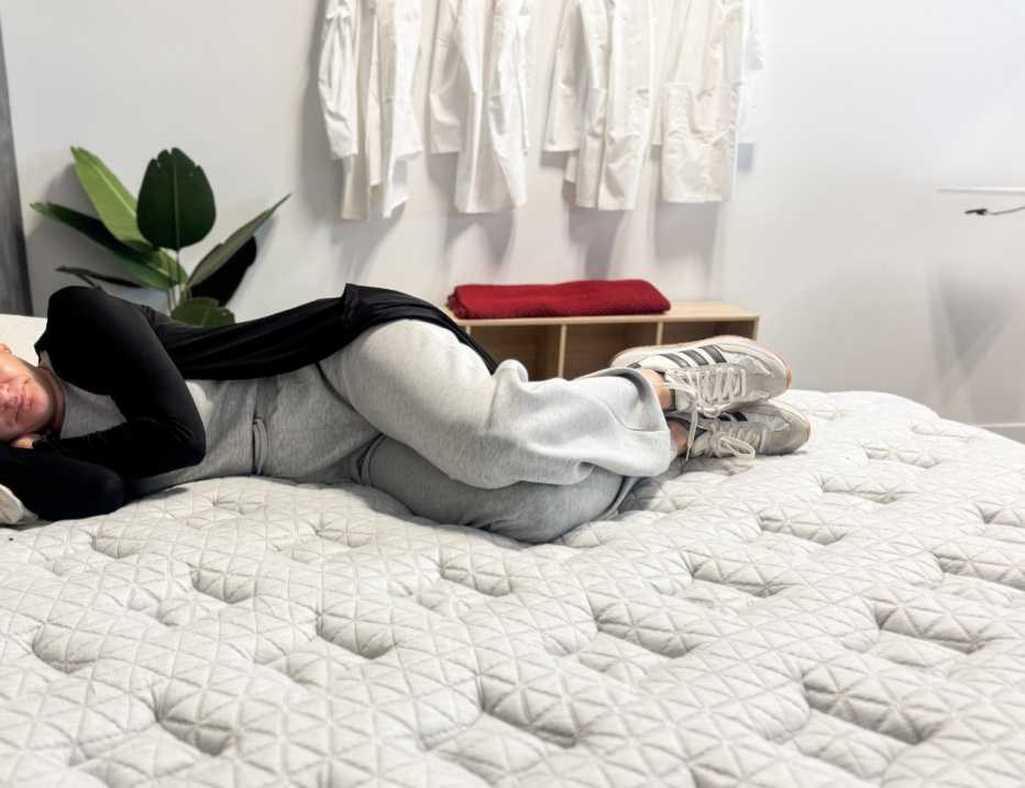 A woman lying on her side on the Helix Dusk Luxe mattress.
