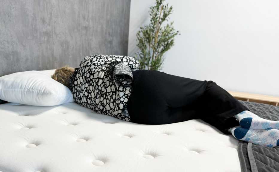 A woman lying on her side on the WinkBed Plus mattress.